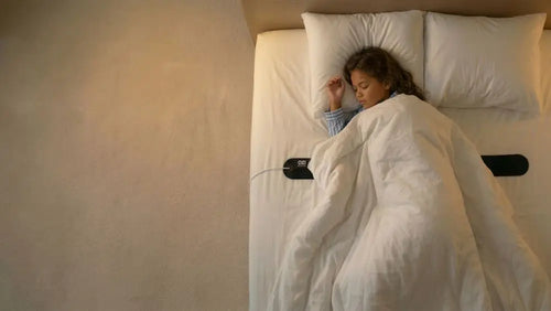 Child sleeping with the OZI Sleep under-sheet sensor in place — non-wearable sleep technology built for kids
