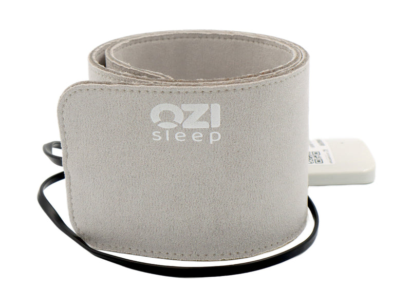 Rolled OZI sleep sensor with its white control module and black cable.